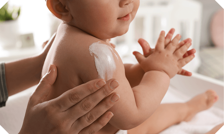 A baby having their head washed by a parent using Oilatum.